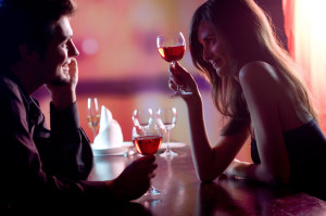 Young couple sharing a glass of red wine in restaurant