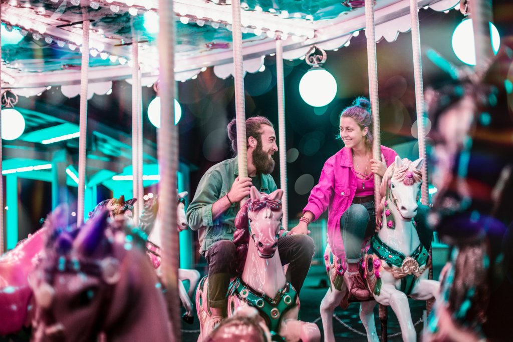 Man and woman smiling on a carousel