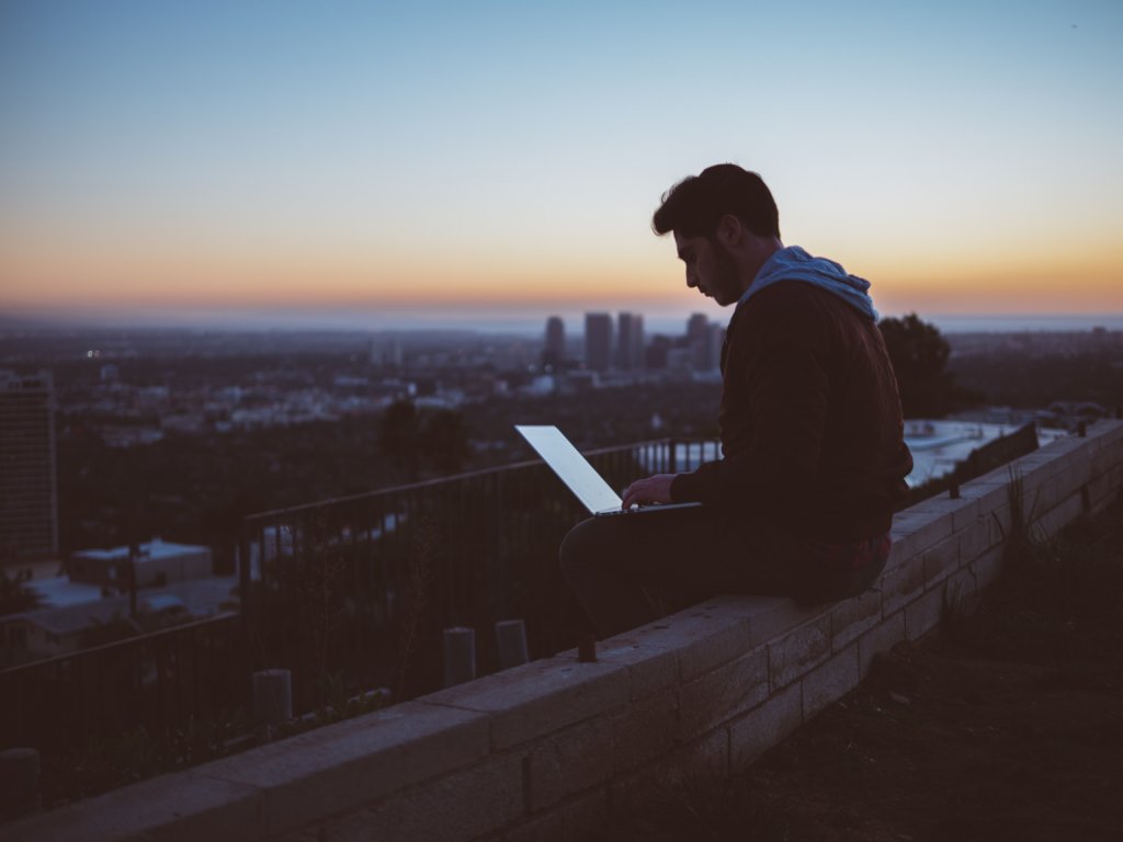 Man working on his laptop overlooking city skyline