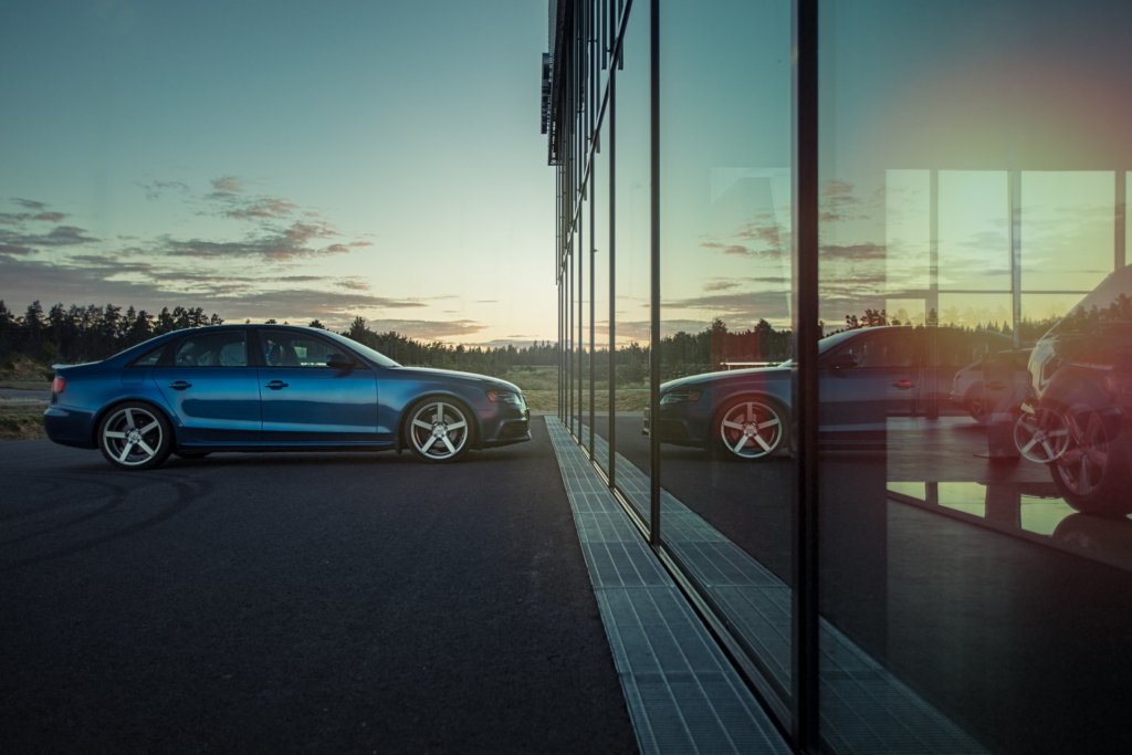 A blue Audi parked in front of a dealership