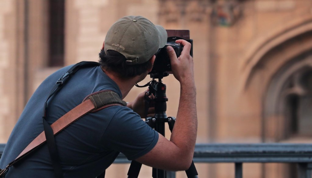 A man taking a picture of the side of a building