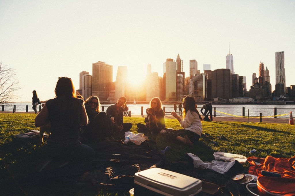 A group of friends enjoying a picnic with a city skyline in the background