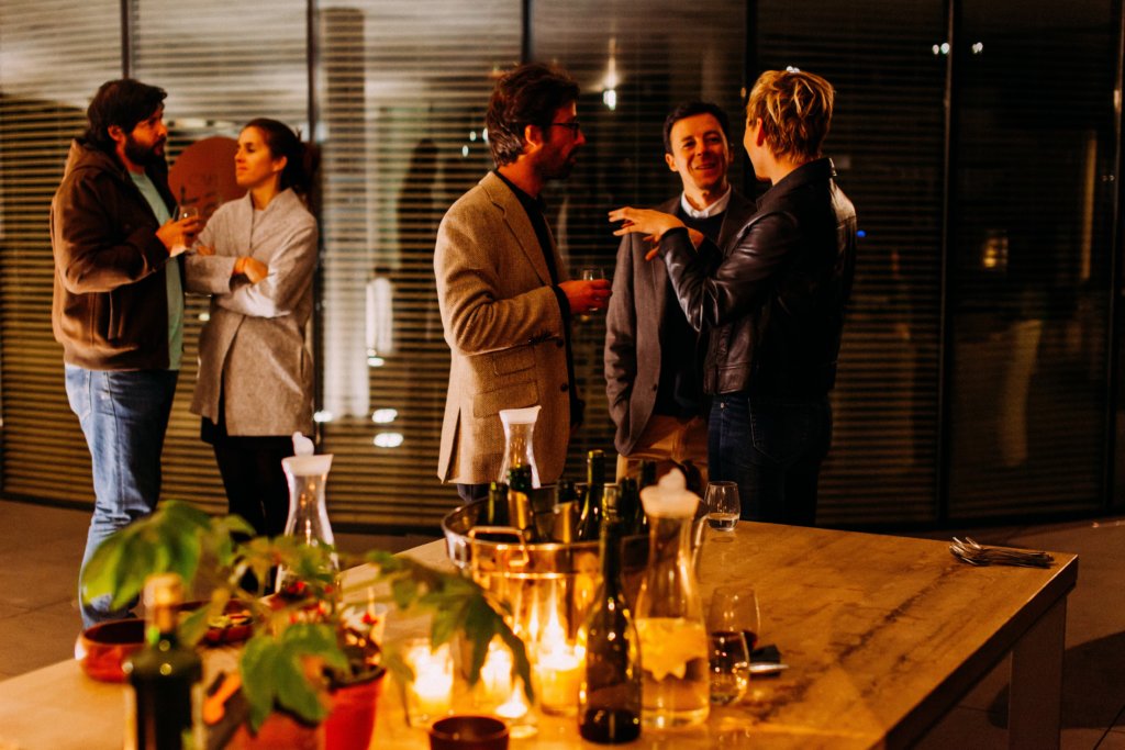 Group of people standing around talking at a networking event