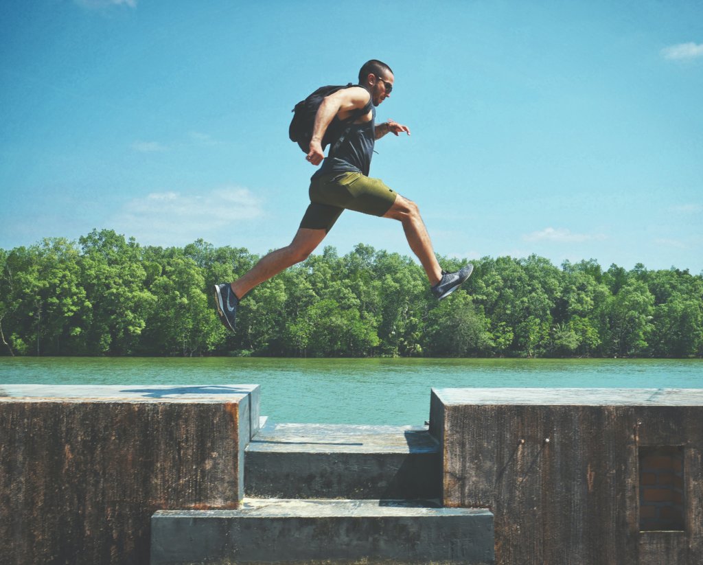 Athletic man jumping from one platform to another