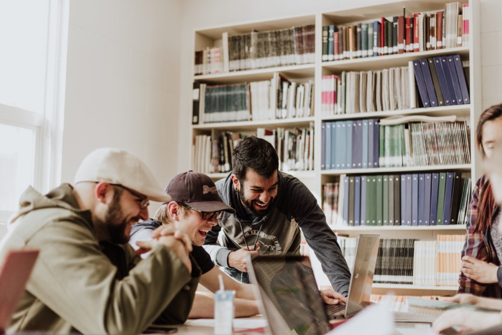 Group of people sitting at a library table having a good time